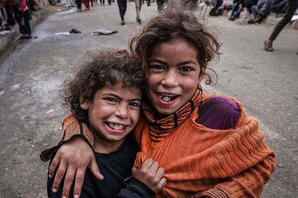 Raseljena palestinska deca poziraju za fotografije u kampu pored ulice u Rafi 14. marta 2024. godine.  - Sputnik Srbija