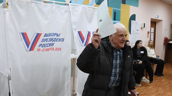Мужчина голосует на выборах президента России на избирательном участке №4127 во Владивостоке - Sputnik Србија