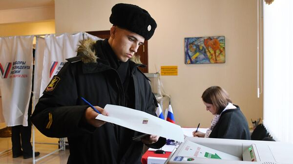Военнослужащий Тихоокеанского флота голосует на выборах президента России на избирательном участке №502 во Владивостоке - Sputnik Србија
