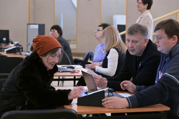 Članovi izborne komisije registruju ženu na predsedničkim izborima u Rusiji na jednom od biračkih mesta u Moskvi. - Sputnik Srbija
