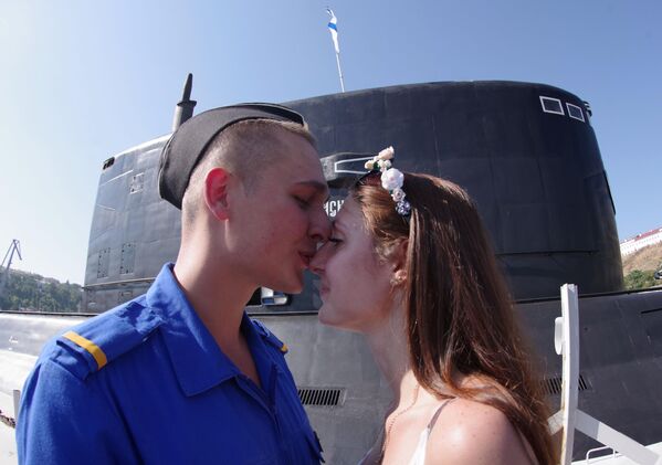 Vojnik sa devojkom ispred nove dizel podmornice „Krasnodar“ u Sevastopolju. - Sputnik Srbija