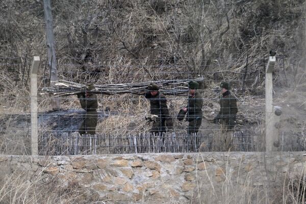 На фотографији су приказани севернокорејски војници који раде на граници, гледано из Тумена у североисточној кинеској провинцији Јилин. - Sputnik Србија
