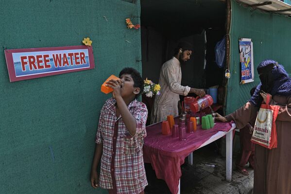 Волонтер дели воду за пиће поред аутобуске станице током врелог летњег дана у Хајдерабаду, Индија, у четвртак, 21. марта 2024. Људи у многим деловима Индије обезбеђујубесплатну воду за пиће пролазницима током летњих месеци. - Sputnik Србија