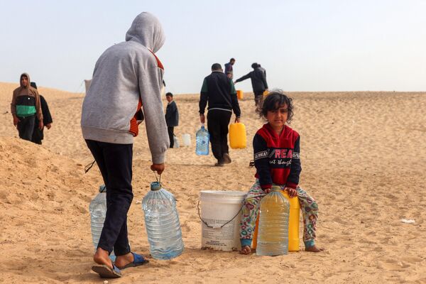 Palestinci transportuju vodu u kamp za raseljena lica u Rafi u južnom pojasu Gaze 17. marta 2024. godine, usred tekućih borbi između Izraela i Hamasa.  - Sputnik Srbija