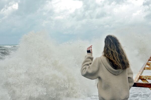 Devojka sa nasipa posmatra olujne talase na Crnom moru u Sočiju. - Sputnik Srbija