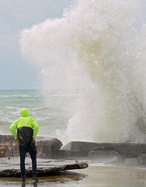 Muškarac posmatra olujne talase na Crnom moru u Sočiju. - Sputnik Srbija