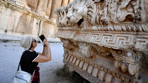 Посетитель фотографирует барельефы в храмовом комплексе древнего ливанского города Баальбек - Sputnik Србија