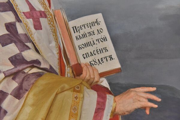 Svetitelj u jednoj ruci drži otvoreno jevanđelje sa ispisanim tekstom: &quot;Preterpjevij že do konca, toj spasen budet&quot; (Ko pretrpi do kraja, taj će se spasti) - Sputnik Srbija