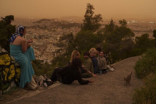 Turisti se igraju sa mačkom u Atini, koja je poprimila &quot;marsovski izgled&quot;. - Sputnik Srbija