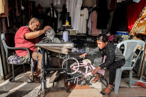 Бицикл као импровизовани извор енергије за кројача у  Рафи у јужном Појасу Газе. - Sputnik Србија