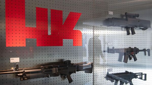 Logo nemačkog proizvođača oružja Heckler & Koch na vitrini sa mitraljezima - Sputnik Srbija