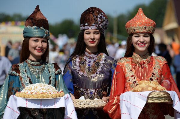 Devojke u narodnim nošnjama dočekuju goste hlebom i solju i čak-čakom pre zvaničnog otvaranja praznika Sabantuj u Kazanju. - Sputnik Srbija