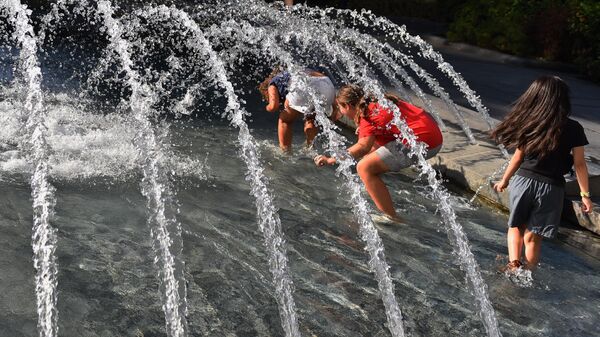 Девојчице се провлаче испод млаза воде у фонтани - Sputnik Србија