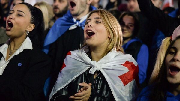 Supporters of Georgia's ruling Georgian Dream party celebrate the party's victory in parliamentary elections at a square outside the Georgian Dream office in Tbilisi, Georgia. - Sputnik Србија