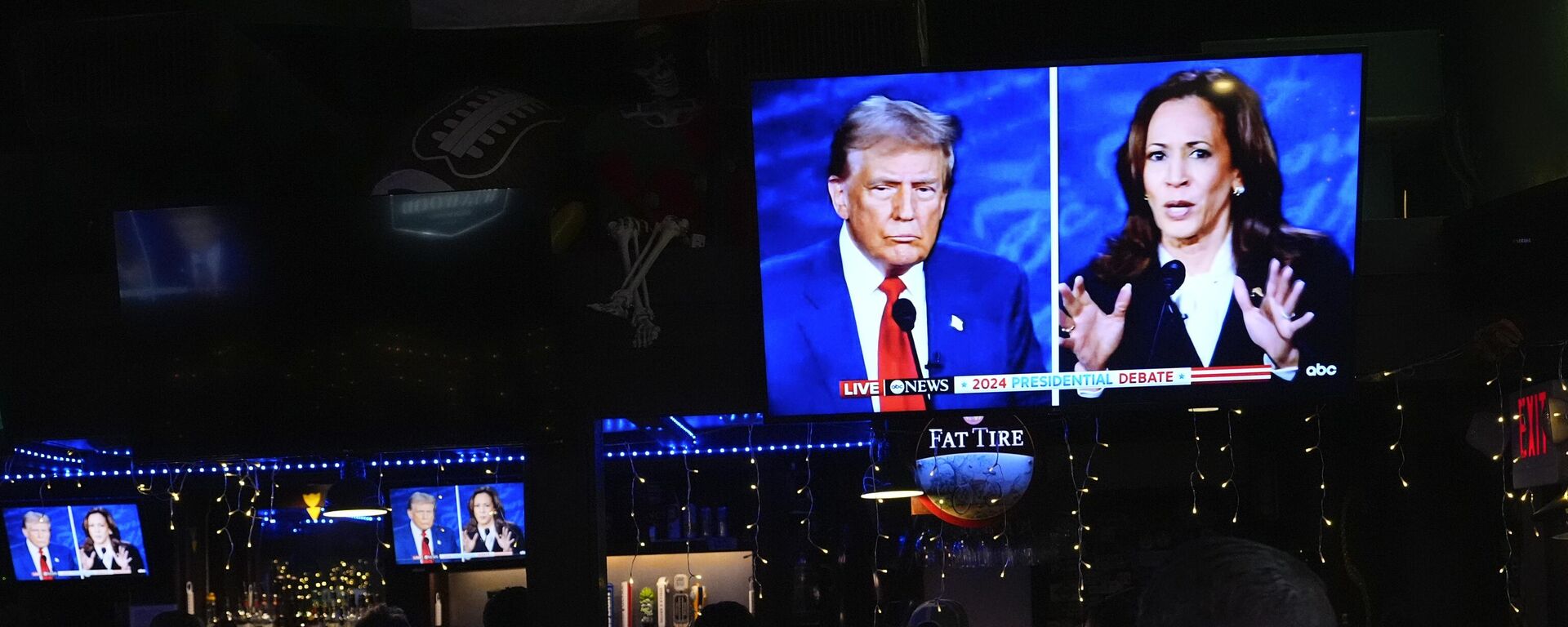 People watch TV screens showing a debate between Democratic presidential nominee Vice President Kamala Harris, right, and Republican presidential nominee former President Donald Trump, at Sports Grill Kendall, where the Miami-Dade Democratic Hispanic Caucus had organized a watch party, Tuesday, Sept. 10, 2024, in Miami.  - Sputnik Србија, 1920, 30.10.2024