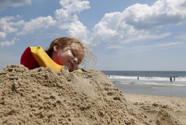 Када вас тата затрпа у песку, једино што можете је да позирате за фотографију и правите се - да спавате. - Sputnik Србија