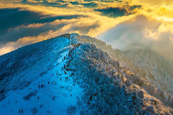 Облаци окружују снегом покривену планину Таизијиан при изласку сунца 24. фебруара 2025. у Хангџоуу - Sputnik Србија