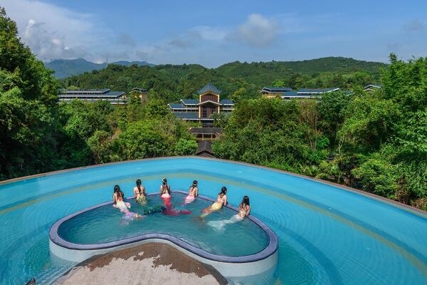 Туристи у костимима сирена пливају у базену у облику срца у одмаралишту у Гуанџонгу. - Sputnik Србија