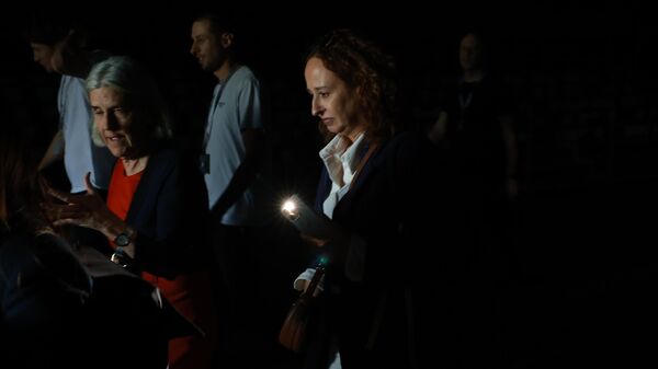 Люди используют свои телефонные фонарики, чтобы пройти по темным проходам во время общего отключения электроэнергии в седьмой день Mutua Madrid Open - Sputnik Србија