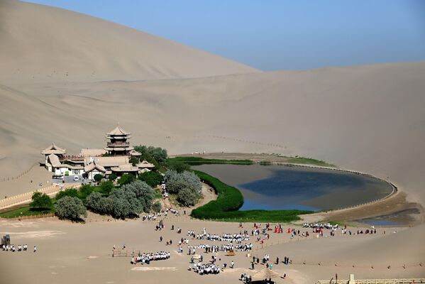 Међу песком на граници пустиња Такламакан и Гоби налази се мало језеро у облику полумесеца. - Sputnik Србија