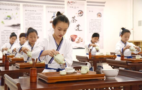 Ученици имају час вештина чаја у основној школи на Међународни дан чаја 21. маја 2021. у Хандану, провинција Хебеј у Кини. - Sputnik Србија
