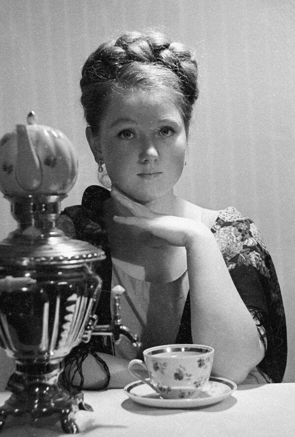 Девојка у позадини самовара се спрема да пије чај. - Sputnik Србија