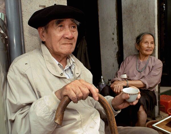 Носећи француску беретку, док испија чај, становник Ханоја ужива у раним јутарњим ритмовима вијетнамске престонице. - Sputnik Србија