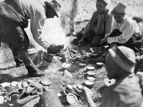 Тибетански сељаци застају у свом послу ради мало освежења, 12. септембра 1933. Цампа се припрема додавањем комада путера и шаке прженог јечменог брашна у чинију чаја. Она је за Тибет оно што је пиринач за Кину. - Sputnik Србија
