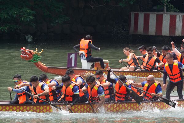 Атмосфера током трике је врло динамична: ударање бубњева прати ритам веслача, а публика дуж обале бодри своје тимове уз повике и навијање. - Sputnik Србија