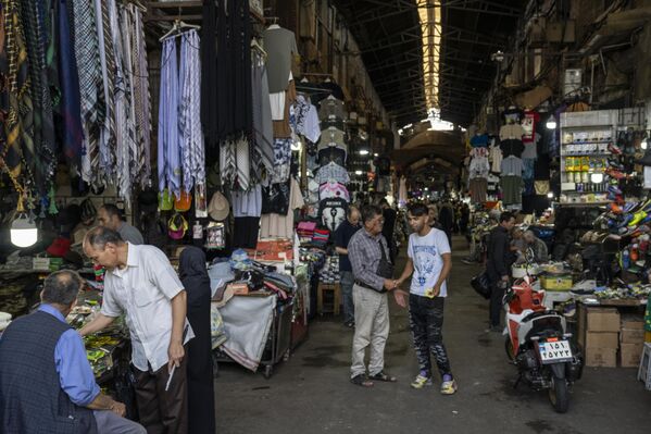 Људи шетају кроз делимично затворену Техеранску пијацу 22. јуна 2025. - Sputnik Србија