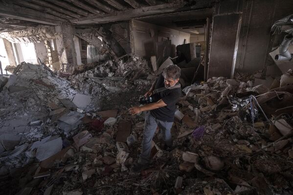 Највише штете од удара претрпео је западни део иранске престонице. На фотографији, орански фото-репортер хода кроз рушевине стана. - Sputnik Србија