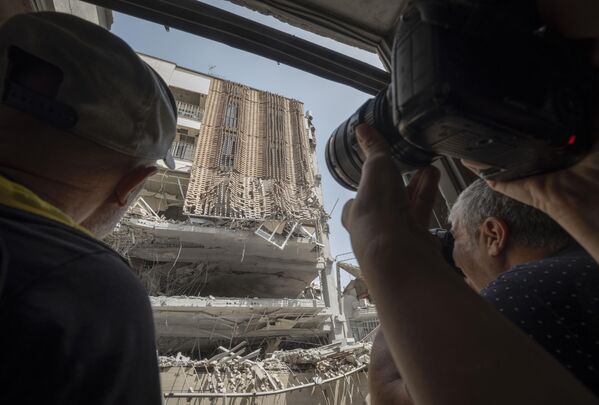 Ирански фоторепортери фотографишу зграду уништену у израелским нападима у западном Техерану. - Sputnik Србија