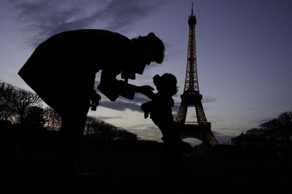 Женa и њена пудла у једном од ретких паркова у Паризу који дозвољавају присуство људи и њихових паса. - Sputnik Србија