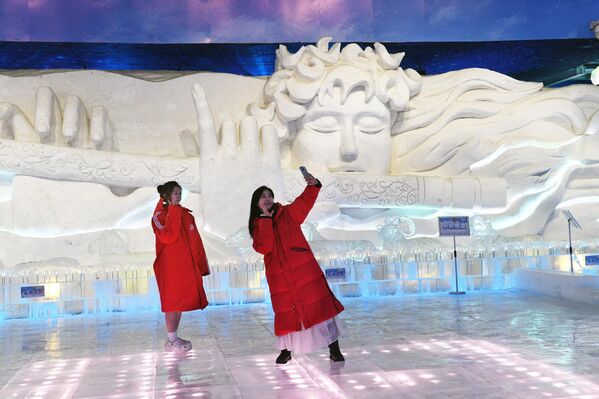 Туристи позирају испред ледених скулптура у Галерији леда и снега у Харбину, у кинеској провинцији Хејлунгђанг. - Sputnik Србија