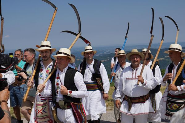 „Позајмио сам ношњу из једног батајничког КУД-а“, рекао је Симић и додао да многи учесници овог такмичења учествују на косидбама широм Србије и региона од Словеније, Хрватске, Купреса, Грмеча ... и освајају златне косе. - Sputnik Србија