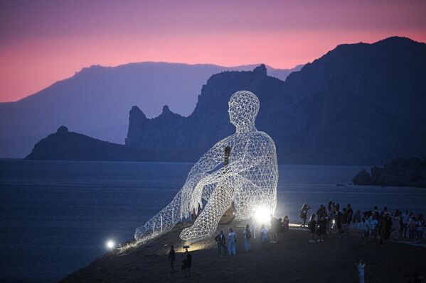 Посетиоци поред уметничке инсталације на месту одржавања фестивала младих стваралаца у култури и уметности „Таврида.АРТ-2025“ у заливу Капсељ. - Sputnik Србија