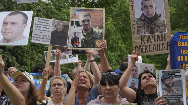 Ukrajinci drže fotografije članova svojih porodica nestalih tokom sukoba u Ukrajini - Sputnik Srbija