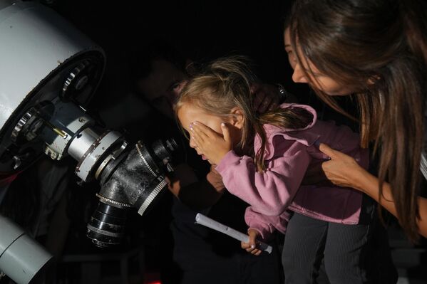 Девојчица посматра метеорски пљусак кроз телескоп у опсерваторији Крајкен Универзитета у Анкари. Метеорски пљусак Персеида се сматра једним од најимпресивнијих природних догађаја године у Анкари, - Sputnik Србија