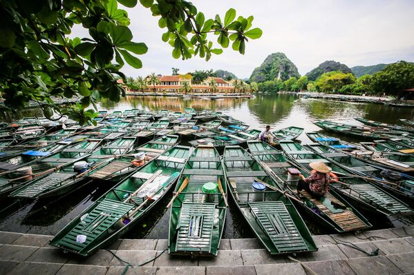 Чамци на обали реке у граду Там Кок, који привлачи посетиоце својим крашким стеновитим формацијама и речним турама у провинцији  Нин Бин, Вијетнам. Овај део земље истиче се природним лепотама, производњом пиринча, туризмом и рукотворинама. - Sputnik Србија