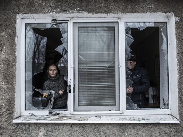 Arhivska fotografija od 18.1.2015. Žena gleda kroz prozor uništen u ukrajinskom granatiranju Donjecka - Sputnik Srbija