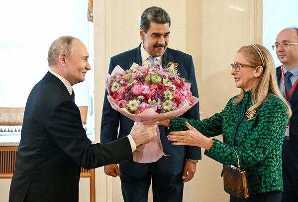 Председник Русије Владимир Путин уручује цвеће супрузи председника Венецуеле, Силији Флорес. Венецуелански председник Николас Мадуро и његова супруга стигли су у Кремљ на свечани концерт за шефове страних делегација позваних на прославу поводом 80. годишњице победе у Другом светском рату. - Sputnik Србија