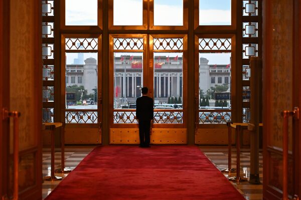 Чувар испред улазних врата у Великој сали народа уочи пријема поводом Националног дана Народне Републике Кине. Велика сала народа је државна зграда западно од трга Тјенанмен у Пекингу. Користи се за законодавне и церемонијалне активности владе. - Sputnik Србија