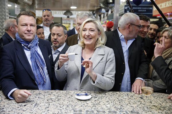 Марин Ле Пен, кандидаткиња за председничке изборе 2022, пије кафу током посете традиционалној пијаци у оквиру изборне кампање 8. априла 2022. у Нарбону, јужна Француска. - Sputnik Србија