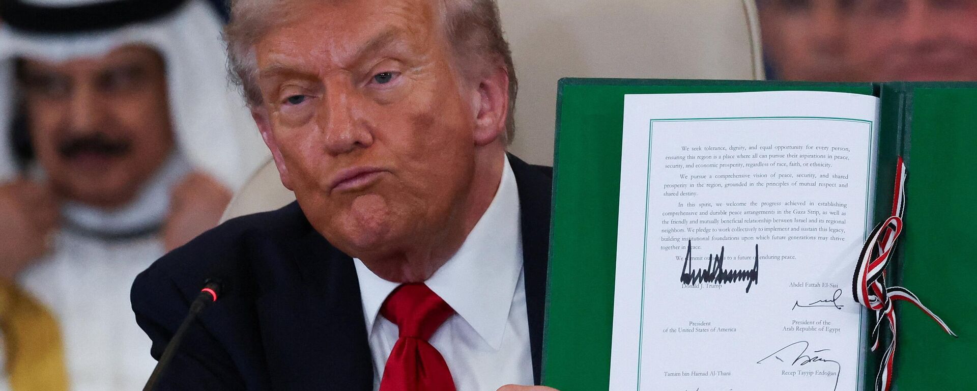 Donald Tramp pokazuje potpisani mirovni sporazum između Izraela i Hamasa. - Sputnik Srbija, 1920, 14.10.2025