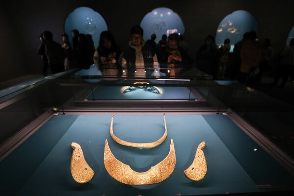 Људи разгледају златне артефакте на изложби. - Sputnik Србија