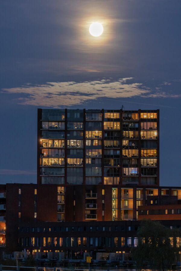 Najveći pun mesec 2025. godine, supermesec poznat kao Dabrov Mesec, izdiže se iznad grada Ajndhovena u Holandiji. - Sputnik Srbija