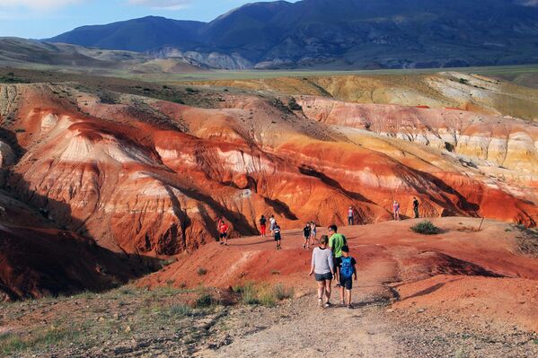 Туристи у долини Кизил-Чин у Чујској степи у Републици Алтај. Висок садржај живе у стени јој даје црвенкасту нијансу. - Sputnik Србија