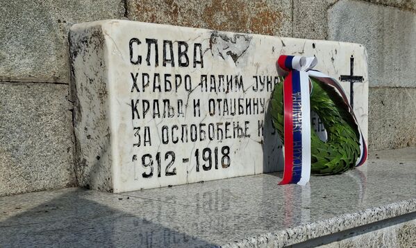 Ploča sa natpisom: „Slava hrabro palim junacima za kralja i Otadžbinu u ratovima za oslobođenje i ujedinjenje na kosturnici i venac koju je položili predstavnici Društva za negovanje tradicije oslobodilačkih ratova do 1918.,  - Sputnik Srbija