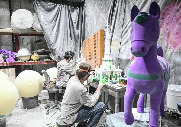 Радници пажљиво фарбају украс у облику зграде у зеленој боји. - Sputnik Србија