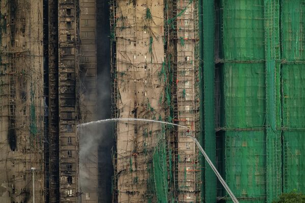 Ватрогсац на дизалици се труди да угаси пожар. - Sputnik Србија